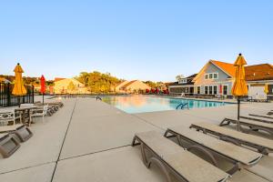 a swimming pool with benches and umbrellas at Beach Shuttle! Spacious Bishop’s Landing Retreat in Ocean View