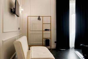 a room with a chair and a shelf in it at Four Rooms Luxury Suite in Palermo