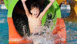 a young boy on a water slide in the water at M Star Columbus North in Worthington