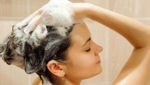 a woman is washing her hair in the shower at M Star Columbus North in Worthington