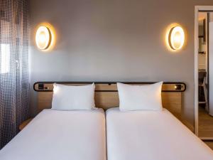 two beds sitting next to each other in a room at Aparthotel Adagio access Montpellier Centre in Montpellier