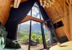 a room with a large window with a view of the mountains at SeSam Villas in Theth