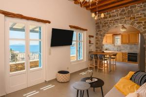 a living room with a couch and a kitchen with a table at Villa Markiani in Aegiali