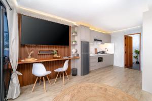 a kitchen and living room with a flat screen tv at Bonbon Beach House in Liloan
