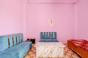 a living room with two blue chairs and a table at SPOT ON S.S HOTEL in Lucknow