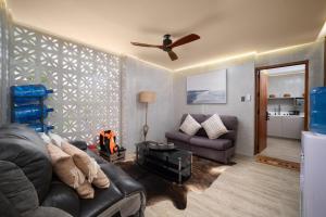 a living room with a couch and a ceiling fan at Bonbon Beach House in Liloan