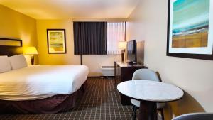 a hotel room with a large bed and a table at Alhambra Hotel in Alhambra