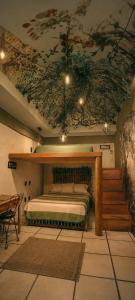 a bedroom with a bed with a painting on the ceiling at Hotel Frida in Mexico City