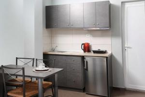 a small kitchen with a table and a refrigerator at Soluna Studios in Polychrono