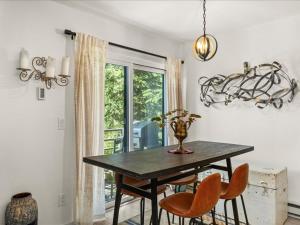 a dining room with a table and chairs and a window at G125 by SkyRun Aspen in Snowmass Village +17 photos