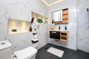 a white bathroom with a toilet and a sink at Bonbon Beach House in Liloan +96 photos