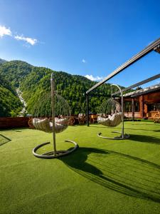 two swings on a lawn with mountains in the background at Ayder Doga Resort in Ayder Yaylasi