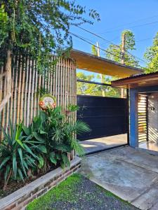 a house with a fence and some plants at Casita pintoresca con entre piso in Posadas
