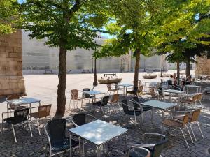 a group of tables and chairs in a courtyard with trees at B&H Boreal in Burgos