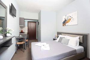 a bedroom with a bed and a desk and a kitchen at Soluna Studios in Polychrono