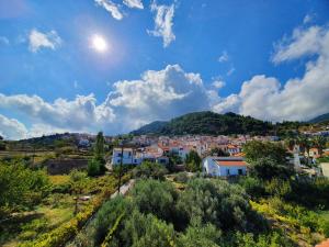 a town on a hill with the sun in the sky at Mary's House in Vourliótai