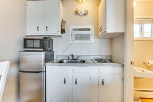 a kitchen with white cabinets and a stainless steel refrigerator at Old Orchard Beach Condo: Steps From the Beach! in Old Orchard Beach