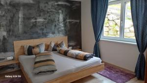 a bedroom with a bed with pillows and a window at Sunhill Apartamente in Karrösten