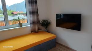 a window seat with a flat screen tv on a wall at Sunhill Apartamente in Karrösten