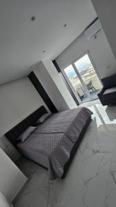 a large bed in a room with windows at DLE Murtic in Shëngjin