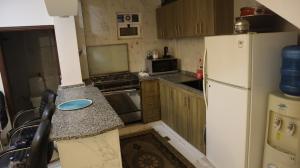 a small kitchen with a refrigerator and a counter at La mira chalet in Madaba +4 photos
