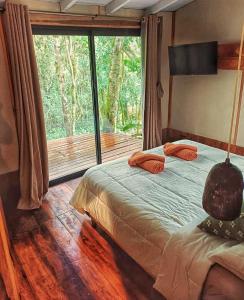 a bedroom with a bed and a large window at ANAVÁ Lodge de Selva y Piscina privada in El Soberbio +21 photos