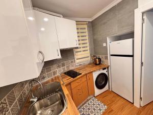 a small kitchen with a sink and a refrigerator at Pretty central flat in Ceuta