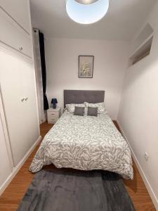 a bedroom with a large bed with a gray comforter at Pretty central flat in Ceuta