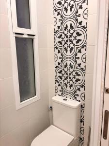 a bathroom with a toilet and a black and white wallpaper at Pretty central flat in Ceuta