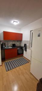 a kitchen with red cabinets and a white refrigerator at Apartment in Bergheim