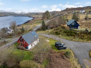 a truck parked in front of a house on a hill at The Wolfie Lodge in Carbost