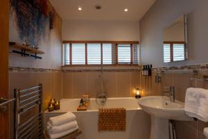 a bathroom with a bath tub and a sink at The Wolfie Lodge in Carbost +47 photos