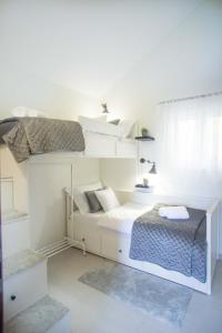a white bedroom with a bunk bed and a window at Kuća za odmor Olea in Stari Grad