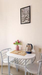 a white table with a tea kettle and flowers on it at Hotel Casa Xicun in Tepoztlán