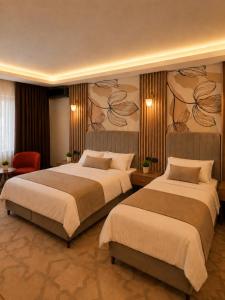 a hotel room with two beds in a room at Lumiera Suites Hotel in Nilüfer