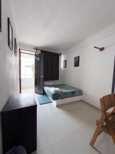 a bedroom with a bed and a chair in it at Hotel Casa Xicun in Tepoztlán