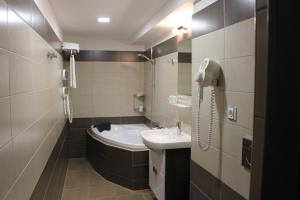 uma casa de banho com um lavatório e um telefone na parede em Hotel u Ledu em Velké Popovice