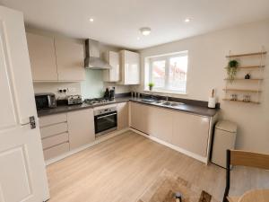 a kitchen with white cabinets and a window at MpaNjus - Double Rooms, Shared House in Bristol
