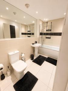a white bathroom with a toilet and a sink at MpaNjus - Double Rooms, Shared House in Bristol +13 photos