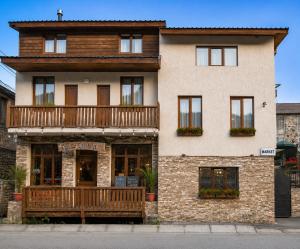 a large brick building with a balcony on it at Guest House Nikala in Mestia