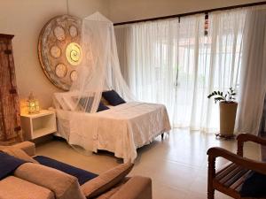 a bedroom with a bed with a mosquito net at Loft Caeté in Araruama