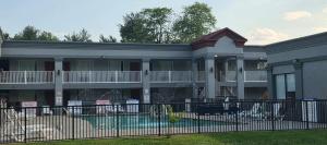 a building with a fence in front of it at HomeTowne Studios by Red Roof Bordentown - McGuire AFB in Bordentown