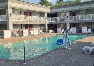 a swimming pool in front of a hotel at HomeTowne Studios by Red Roof Bordentown - McGuire AFB in Bordentown