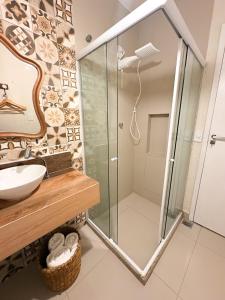 a bathroom with a glass shower and a sink at Loft Caeté in Araruama +13 photos