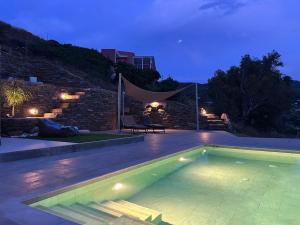 a swimming pool in a backyard at night at Gaia & Thalassa Villa Nafsika in Otziás