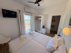 a large white bed in a room with a window at Windmill Rooms in Antiparos