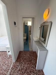 a small bathroom with a mirror and a sink at Windmill Rooms in Antiparos +19 photos