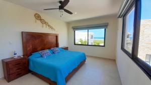 a bedroom with a blue bed and a large window at Corcomoran Luxury beachfront house in Telchac Puerto +42 photos