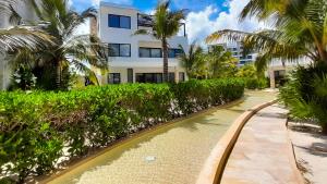 a river in front of a building with palm trees at Corcomoran Luxury beachfront house in Telchac Puerto