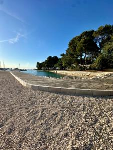 a walkway next to the water on a beach at APP Steps to the Sea 2026 in Funtana